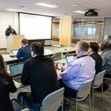 Maple Disruption 2025 partners listen to a presentation on cross-sector collaboration.